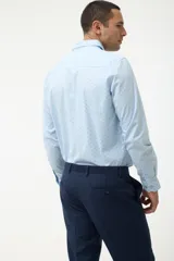 Camisa azul marino con pequeños lunares celestes, de corte clásico y manga larga.