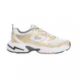 Championes Lacoste modelo Storm 96 2K, con diseño deportivo de estilo retro. Presenta una combinación de malla blanca y paneles superpuestos en tono dorado metalizado, con el logo del cocodrilo en el lateral. Suela robusta con detalles en gris y negro.