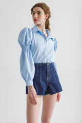 Short de jean de tiro medio color azul oscuro, con calce holgado y terminación desflecada.