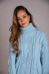 Suéter tejido de punto trenzado color salmón, con cuello alto y mangas largas. Corte ajustado al cuerpo.