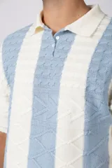 Chomba de punto con diseño de rayas verticales en color celeste y blanco, cuello tipo polo con cierre de botones y mangas cortas.