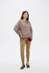 Sweater de tejido de punto con efecto jaspeado, corte holgado y cuello redondo. Presenta mangas largas con puños en contraste de color, uno en tono oscuro y otro en tono rojizo.