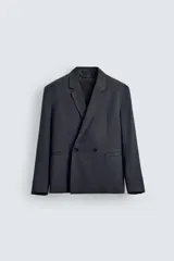 Blazer de corte relajado confeccionada en tejido con lana. Presenta cuello con solapas de muesca, manga larga con puños abotonados, bolsillos de vivo en la cadera y bolsillo interior. Cierre frontal de doble botonadura.
