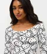 Pijama de dos piezas con estampado integral de Hello Kitty. Incluye una blusa de manga larga con cuello redondo y un pantalón con cintura elástica, confeccionado en tejido acanalado.