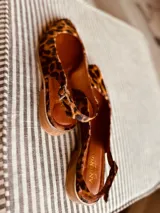 Chatas con estampado animal print, con talón descubierto y tira trasera.