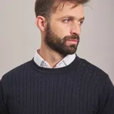 Sweater azul marino de punto trenzado, con cuello redondo y mangas largas.