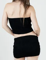 Top strapless negro confeccionado en tejido elástico texturado, con diseño ajustado al cuerpo.