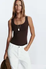 Camiseta blanca ajustada de poliamida con tirantes anchos y escote redondo.