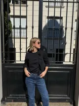 Remera negra de mangas largas con detalle de frunces en el frente.