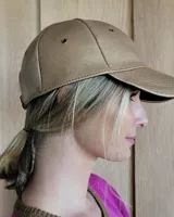 Gorra tipo visera confeccionada en cuero con textura de pelo, diseño clásico con ojales metálicos de ventilación y ajuste posterior.