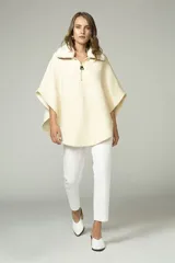 Poncho color crema con cuello de corderito desmontable y cierre dorado.