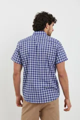 Camisa de manga corta con estampado a cuadros en tonos azul oscuro y celeste. Tiene cuello abotonado y corte clásico.