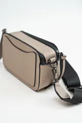 Bandolera de diseño rectangular en color negro, confeccionada en material texturizado. Cuenta con una correa de hombro ajustable y extraíble, cierre superior y tiradores laterales decorativos.