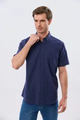Camisa de manga corta confeccionada en mezcla de lino y algodón, color beige, con cuello camisero abotonado, bolsillo frontal en el pecho y cierre de botones.