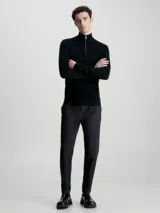 Sweater negro de lana merino con cuello alto y cremallera corta.