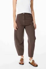 Jean de corte balloon en color azul marino, con cintura alta, cierre frontal con botón y bolsillos laterales. Presenta costuras laterales curvadas que definen su silueta amplia y relajada.