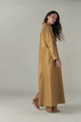 Vestido camisero largo color ocre, con cuello camisero, abotonadura frontal y mangas largas con presillas.