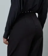 Pantalón de sastrería corte wide leg color negro, con pliegues delanteros, trabillas y cinturón incluido con detalles metálicos. Confeccionado en tejido estructurado con caída fluida.