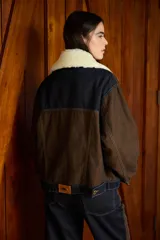 Chaqueta de denim color marrón con costuras a la vista, cuello de lana desmontable en color crema y cierre frontal con botones metálicos.