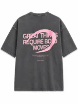 Remera oversize de algodón pesado con efecto lavado, color gris, de manga corta y cuello redondo. Presenta un gran estampado en la espalda con la frase "Great things require bold moves" en color rosado.