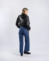 Campera tipo bomber de símil cuero color negro, con cuello, puños y ruedo elásticos. Cuenta con cierre frontal y dos bolsillos diagonales con cierre.