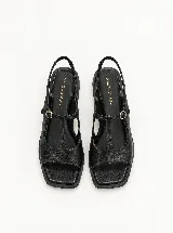 Sandalias Margara Shaw modelo Daisy de cuero color negro, con diseño en T, puntera cuadrada, taco bajo de 3 cm, tira ajustable en el empeine con hebilla dorada y tira elástica en el talón.