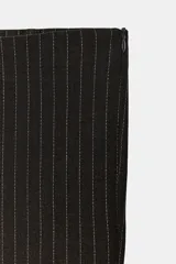 Pantalón capri negro con sutiles rayas verticales marrones, de tiro medio y corte recto.