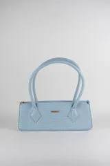 Cartera tipo baguette color negro con textura efecto cocodrilo, diseño alargado, doble asa de mano y cierre superior.