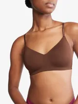 Corpiño marrón de Calvin Klein, ligeramente forrado, sin aros, con escote en V y tirantes ajustables con logo de la marca. Cierre con broche en la parte posterior.