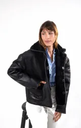 Chaqueta reversible de cuero napalan con interior de corderito negro. Presenta cuello solapa, cierre frontal con botones y bolsillos laterales.