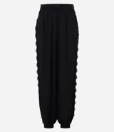Pantalón balloon de crepé negro, de corte amplio y cintura elástica, con detalles de encaje en los laterales y puños inferiores elastizados.