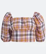 Blusa cropped de algodón con estampado de cuadros en tonos blanco, naranja, marrón y negro. Tiene escote cuadrado, mangas cortas abullonadas y lazo en la espalda.
