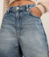 Bermuda de jean celeste con lavado dirty, tiro alto, corte amplio y terminación deshilachada.