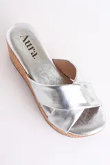 Sandalia color beige con plataforma de corcho y tiras cruzadas de cuero.