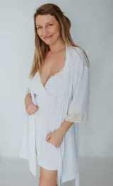 Bata blanca de jersay elastizado con puntilla en las mangas.