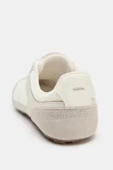 Championes de estilo retro running en tonos beige, confeccionados con paneles de gamuza y textil. Presentan cierre mediante cordones, punta redonda y suela de goma dentada.