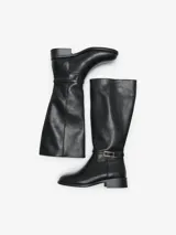 Botas de caña alta efecto cuero color negro, con punta almendrada, taco bajo y detalle de tira con hebilla metálica en el tobillo.
