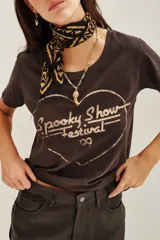 Remera de algodón en color gris oscuro con efecto desgastado. Presenta un estampado frontal en forma de corazón con la inscripción 'Spooky Show Festival' en tono claro.
