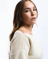 Buzo de lana merino con cuello bote y mangas largas. Presenta un detalle bordado a mano en color azul en la parte inferior.