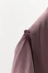 Camisa de manga larga confeccionada en mezcla de lyocell, con cuello fluido tipo pañuelo integrado, cierre frontal con botones ocultos por solapa y bajo redondeado asimétrico.