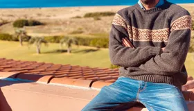 Sweater gris con diseño geométrico en el pecho, confeccionado en lana merino.