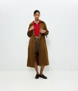 Trench coat largo de gamuza sintética color marrón, con cuello solapa, cierre frontal con botones, cinturón ajustable a la cintura y trabas regulables en los puños.