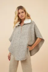 Poncho color crema con cuello de corderito desmontable y cierre dorado.