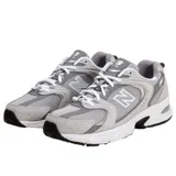 Championes New Balance 530 de estilo retro, color gris con detalles en blanco y negro, confeccionados con malla transpirable y superposiciones de material sintético. Cuenta con tecnología ABZORB en la entresuela para mayor amortiguación y suela de goma.
