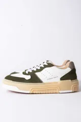 Championes urbanos Urban Haus modelo Mauro, con diseño de paneles en cuero blanco y gamuza verde oliva. Presentan suela de plataforma de goma en tono beige, cierre con cordones blancos y logo de la marca grabado en el lateral.