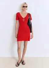 Vestido corto de punto fino color rojo, con escote en pico y detalle de lazos frontales. Presenta mangas cortas y un diseño evasé.