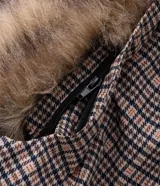 Campera masculina de corte regular con estampado a cuadros, cierre frontal con cremallera y capucha fija con borde de pelo sintético. Cuenta con bolsillos frontales con solapa y cierre de botón a presión.