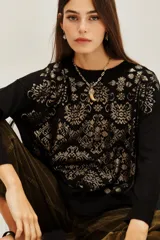 Sweater negro de manga larga con cuello redondo y tejido jacquard en dorado con diseño damasco.