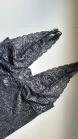 Topcito tipo bralette de encaje negro con escote en V profundo y tirantes anchos. El encaje es elastizado para un ajuste cómodo.