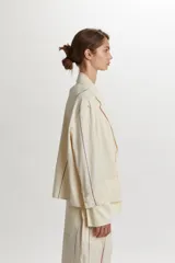 Chaquetas de algodón y lino color beige, con diseño de rayas finas y cierre frontal de botones.